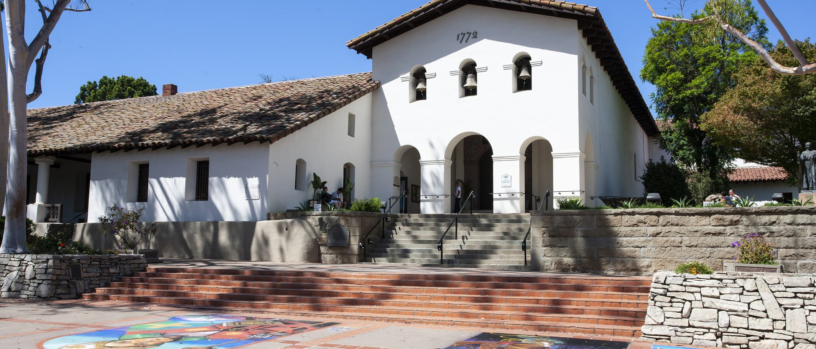Mission San Luis Obispo de Tolosa with colorful chalk art on the plaza in front